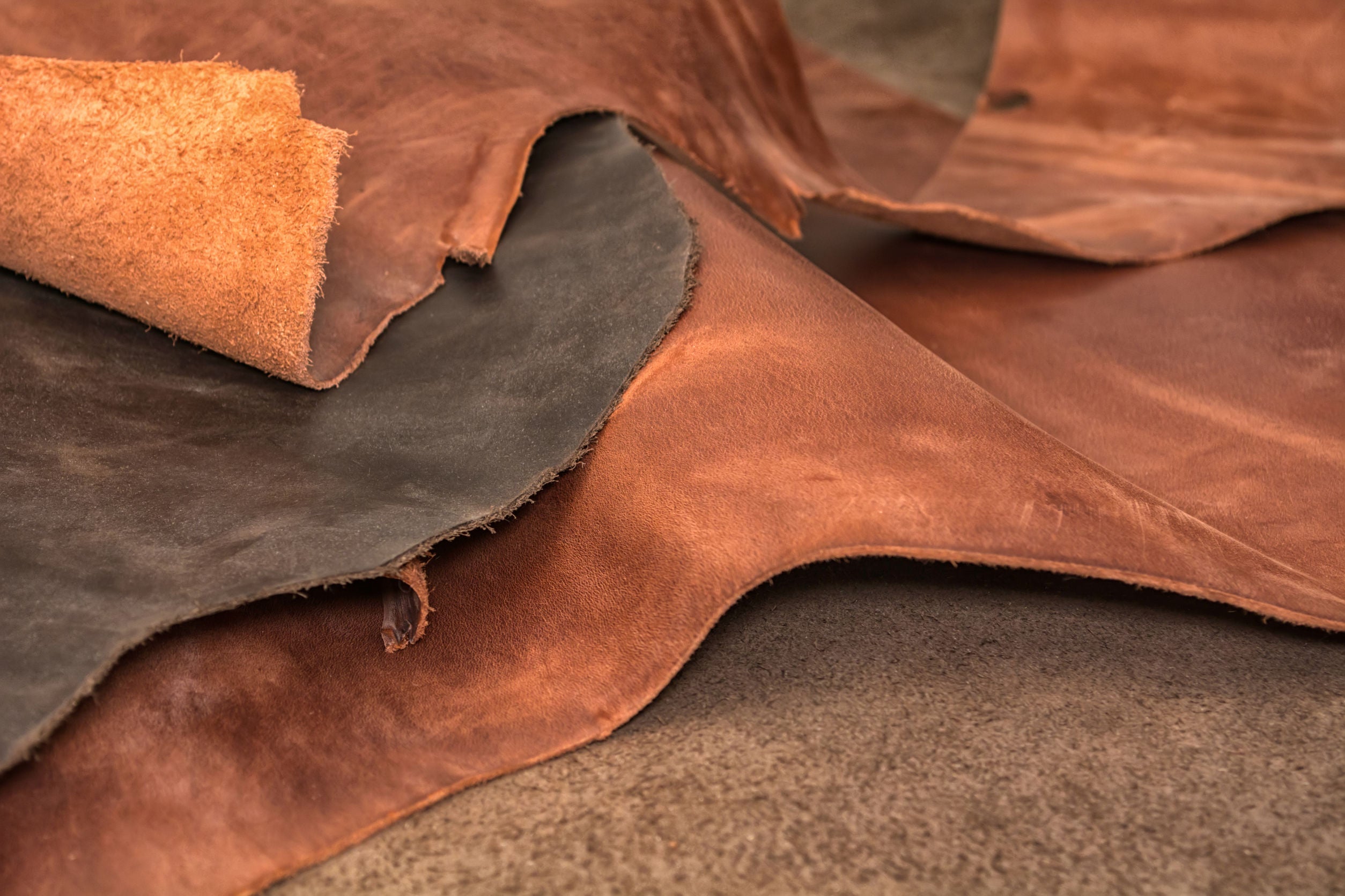A few different pieces and types of leather all laying on top of each other.