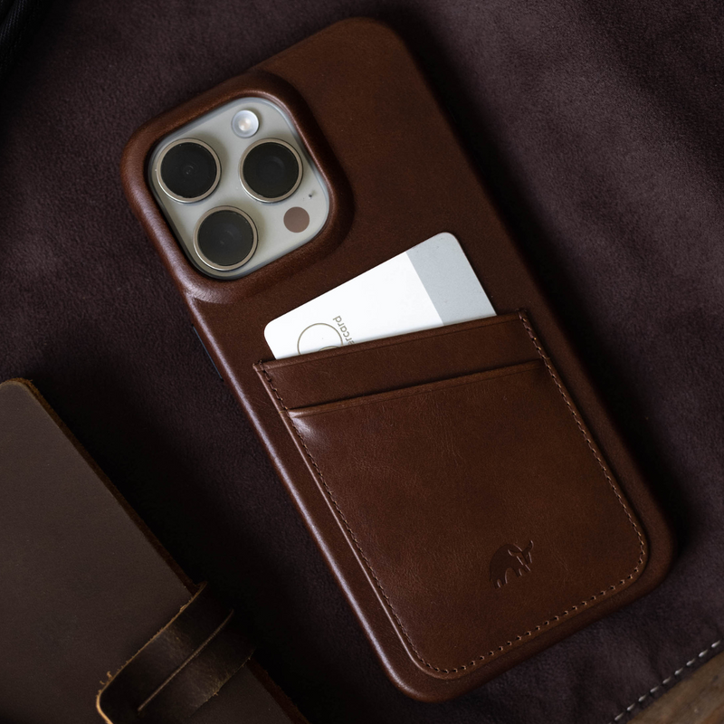 Brown leather iPhone case with stitched card pocket holding a white card reading stocard and triple camera