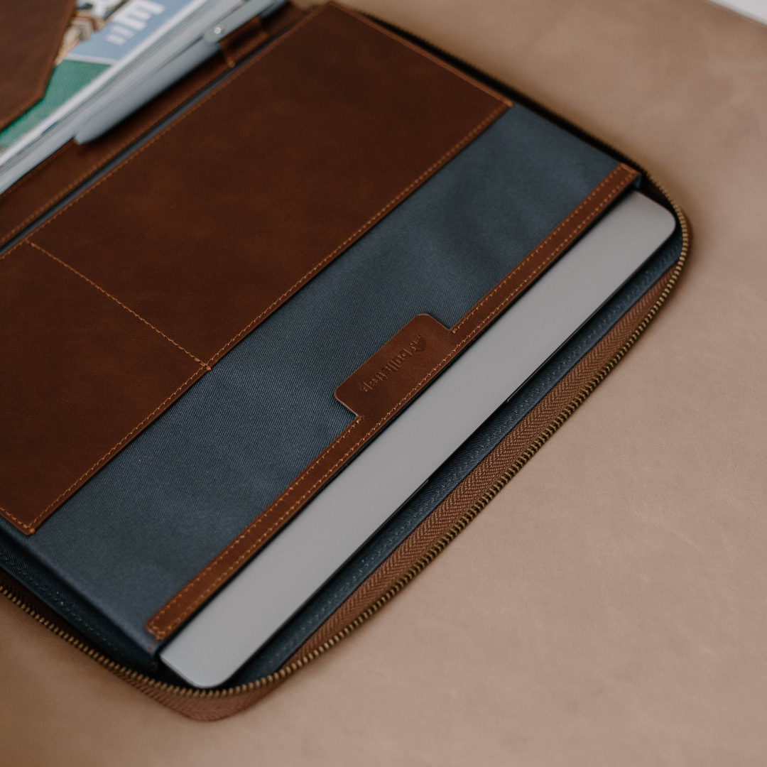 Interior view of the Leather MacBook Sleeve showing compartments and a MacBook inside.
