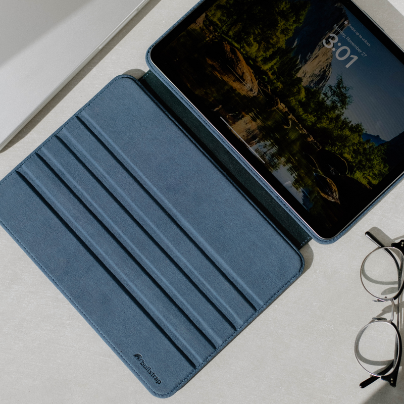 Top-down view of Ocean leather iPad case open showing suede-lined interior with fold grooves and an iPad on a light tabletop