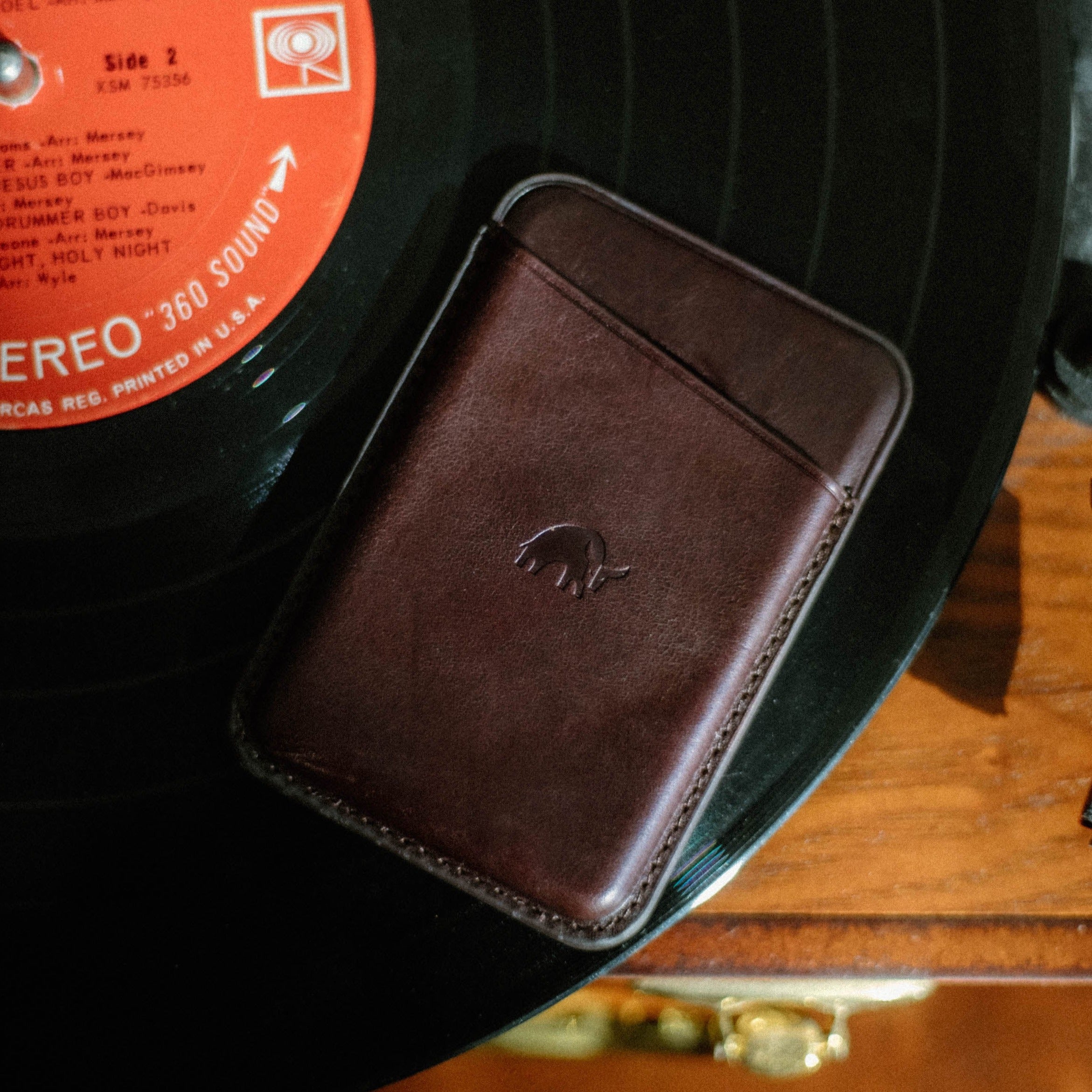 Leather Magnetic Wallet in Bourbon color on a vinyl record
