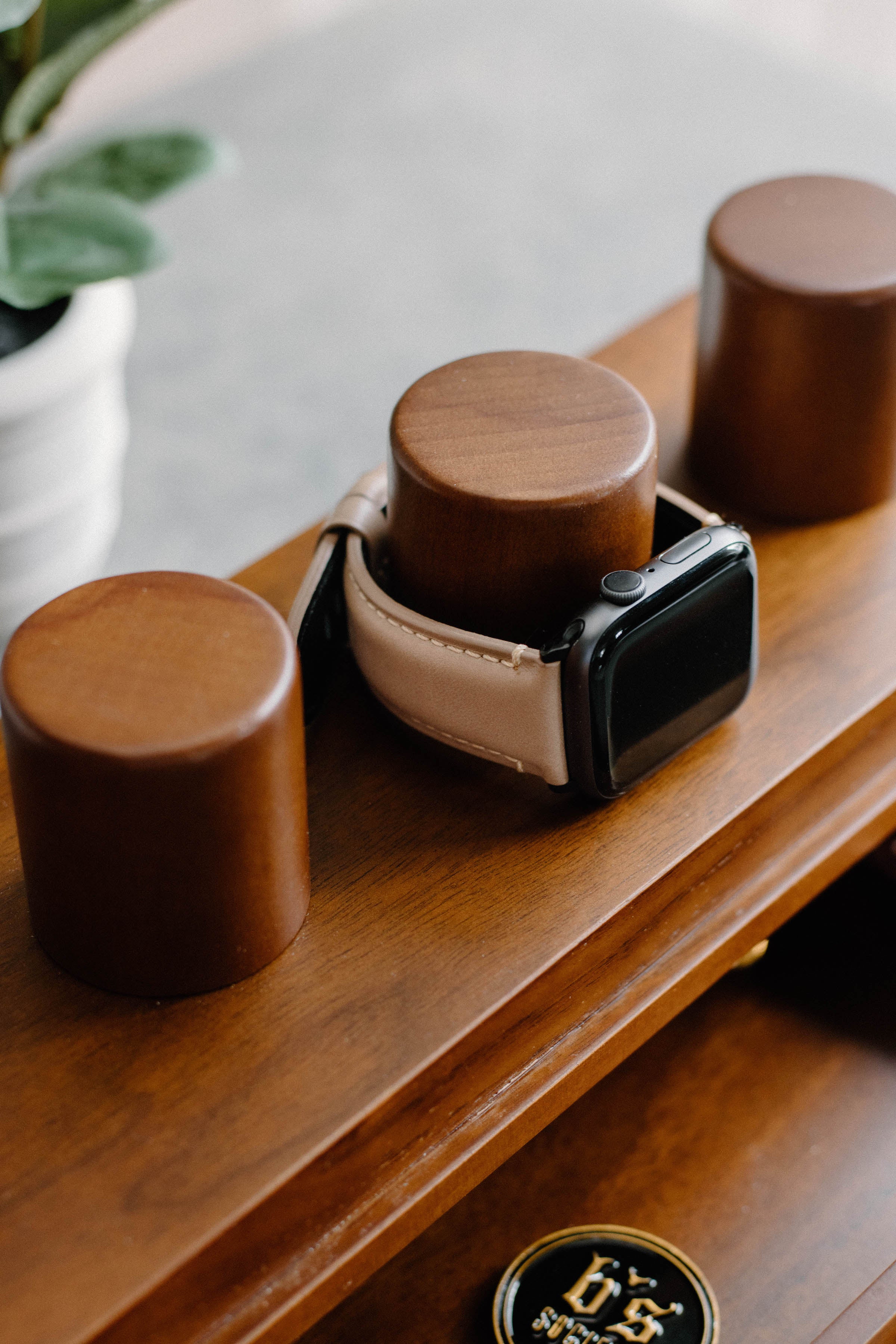 Leather Apple Watch strap displayed on wooden stand