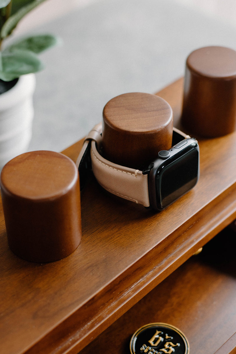 Leather Apple Watch strap displayed on wooden stand