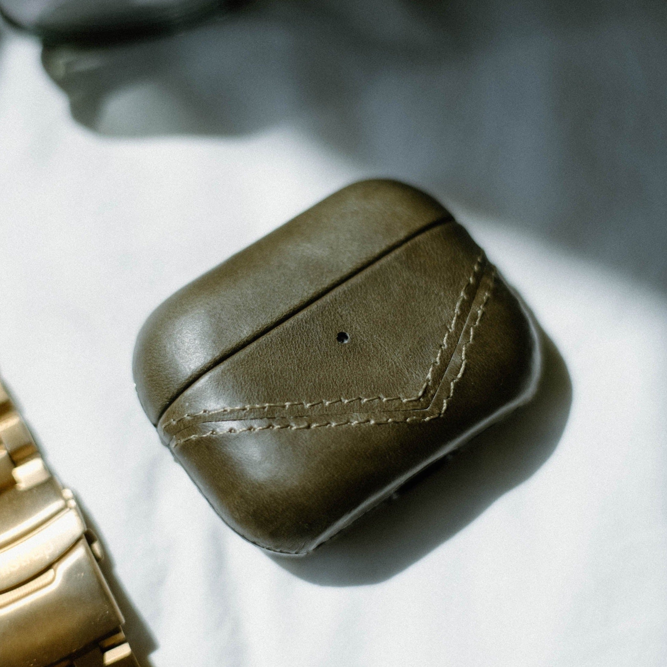 Leather AirPods case in olive green with stitching detail