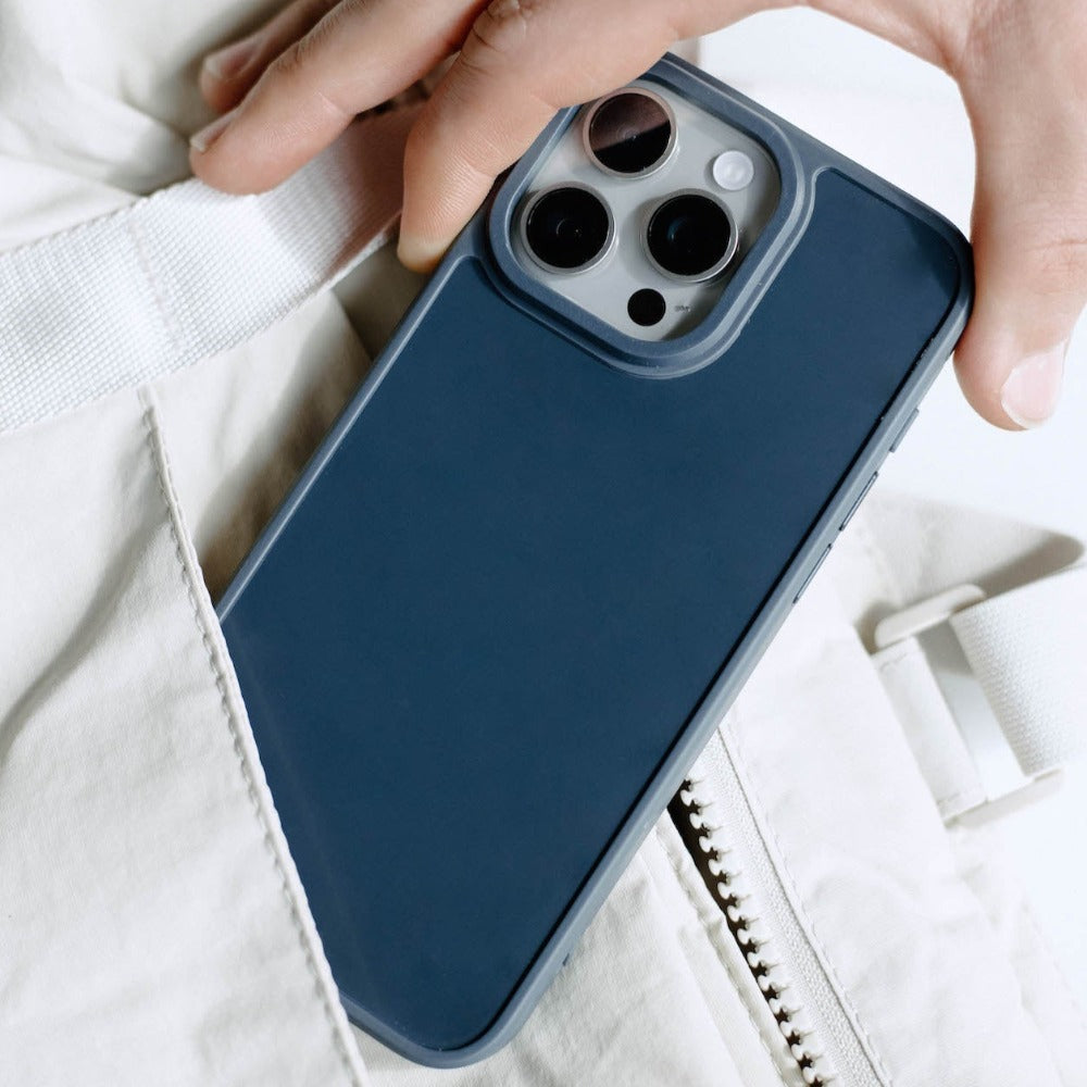 A hand holding a navy blue FRWD phone case with three camera lenses visible.