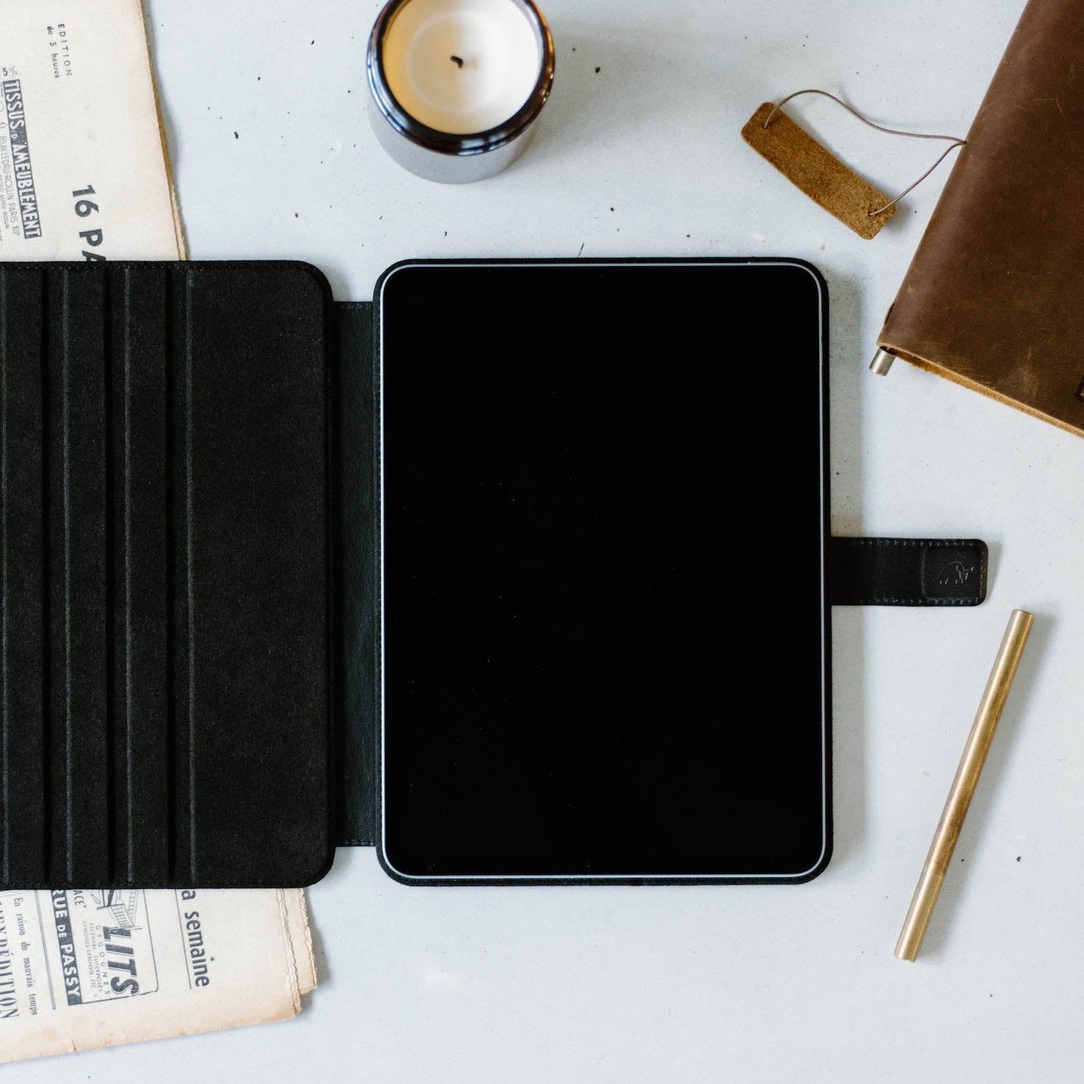 Open leather iPad case with a black interior and a tablet inside.