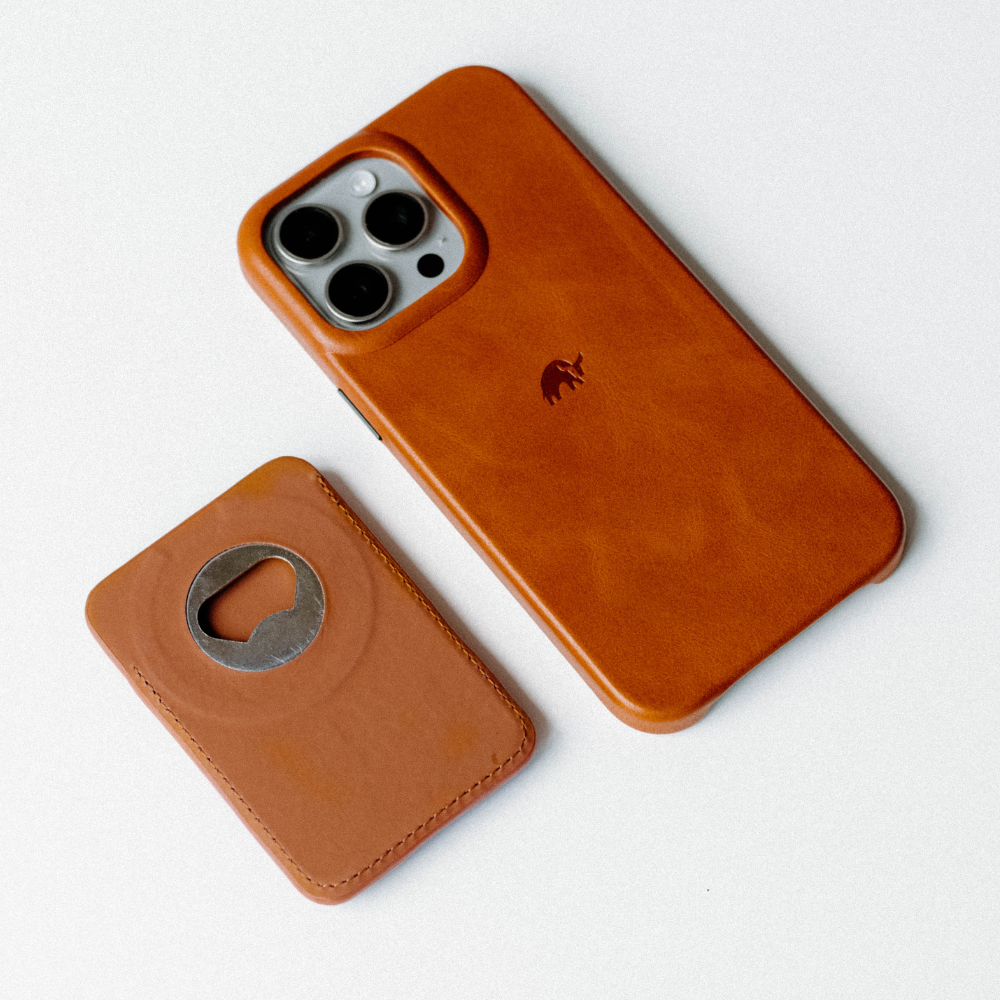 Sienna leather popper card wallet beside matching iPhone case, showing camera cutout and embossed elephant logo