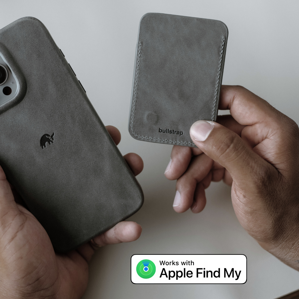 Gray leather card wallet labeled bullstrap held beside a matching phone case; badge reads 'Works with Apple Find My'.