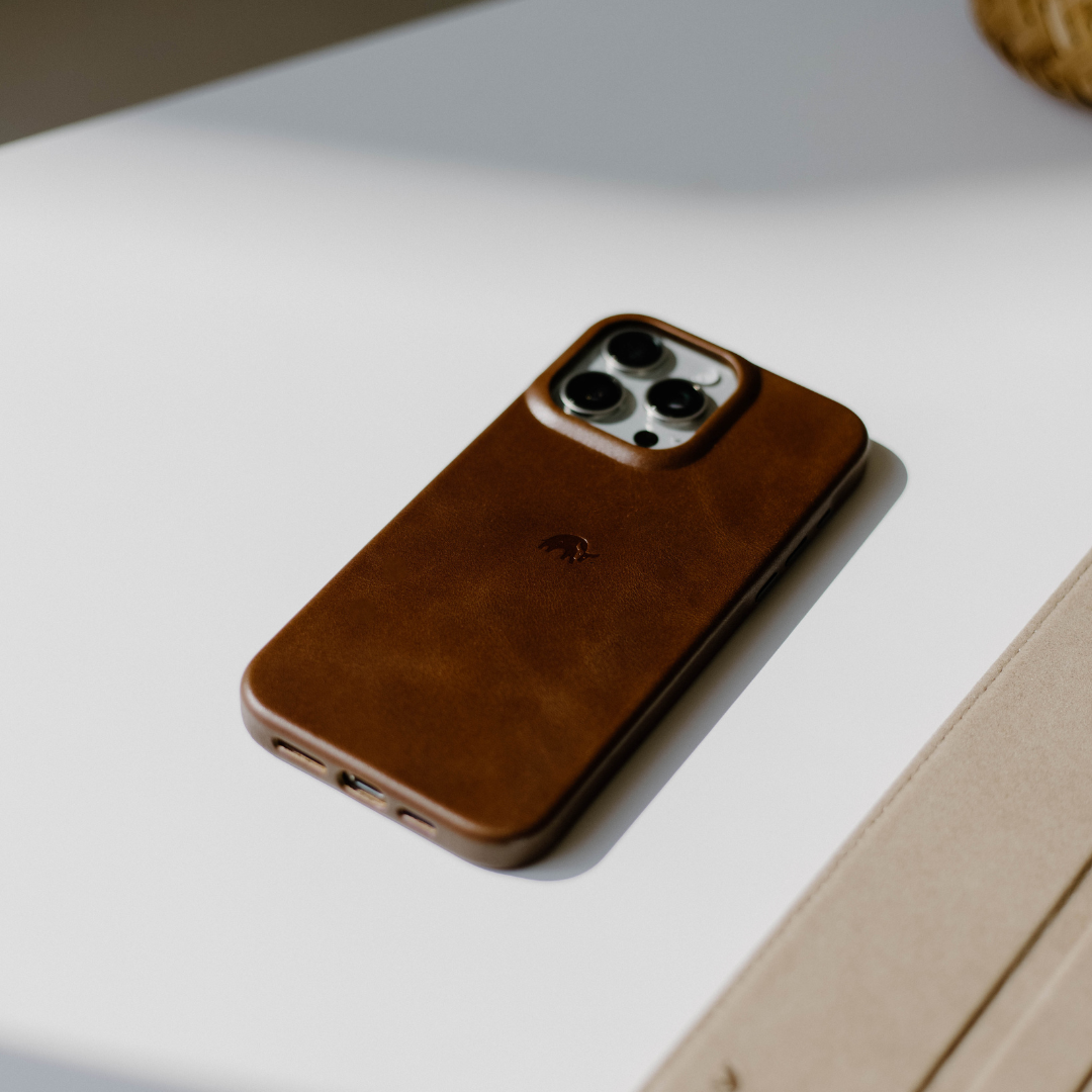Brown leather iPhone case with camera cutout on a white surface