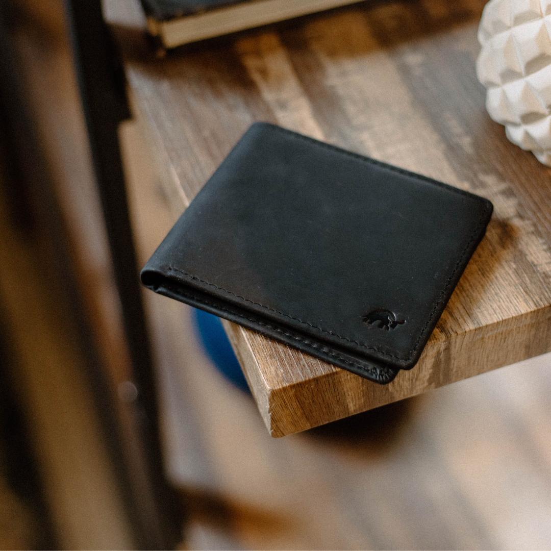 Black bifold wallet resting on a wooden table
