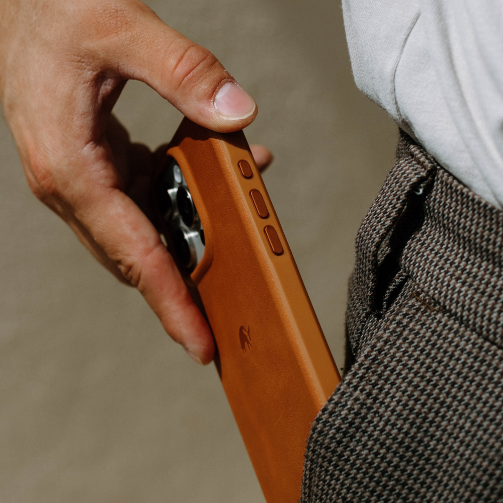 A person holding the Flex Case - SIENNA phone case, partially inserted into their pocket.