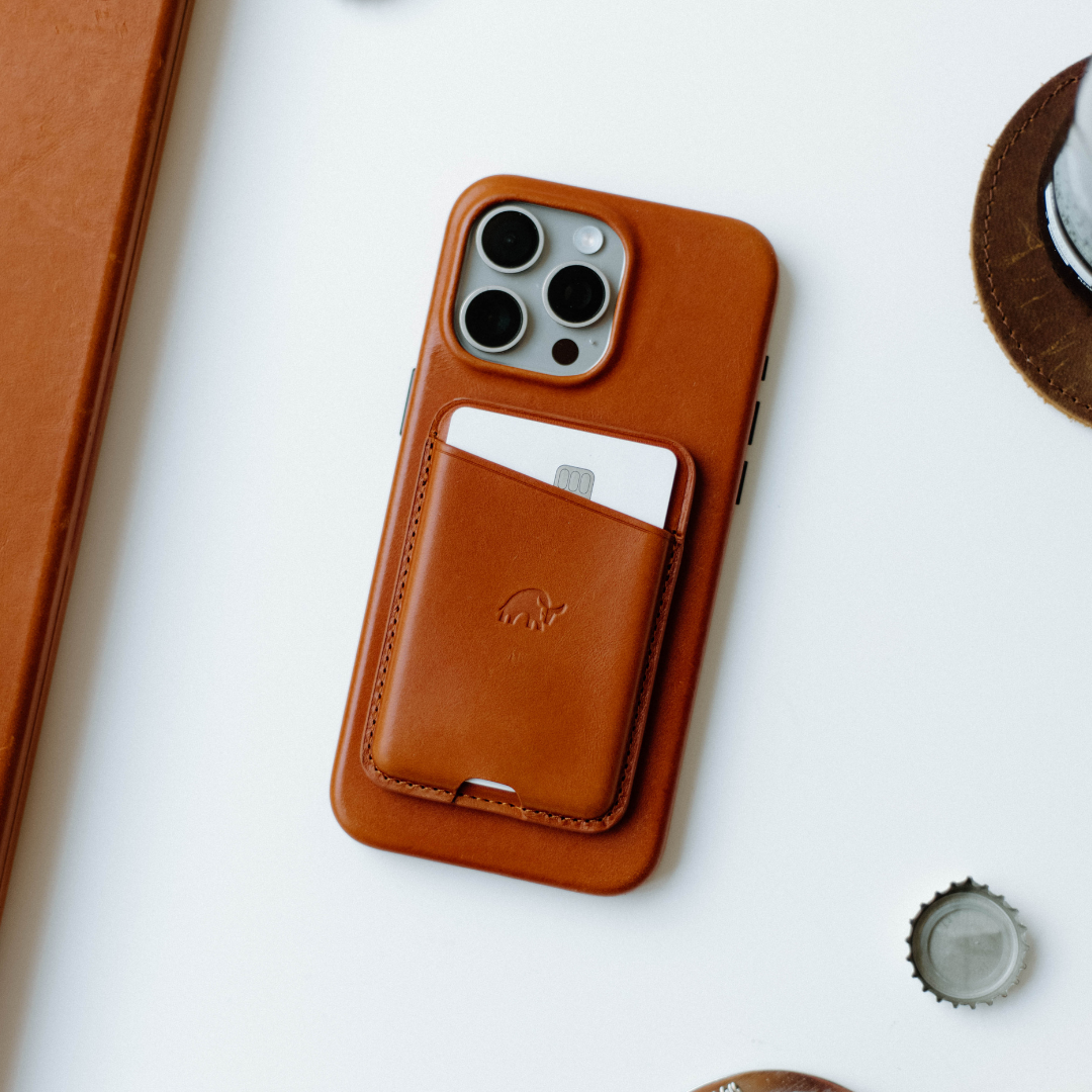 Sienna leather MagSafe Popper wallet attached to iPhone case with one card partially visible
