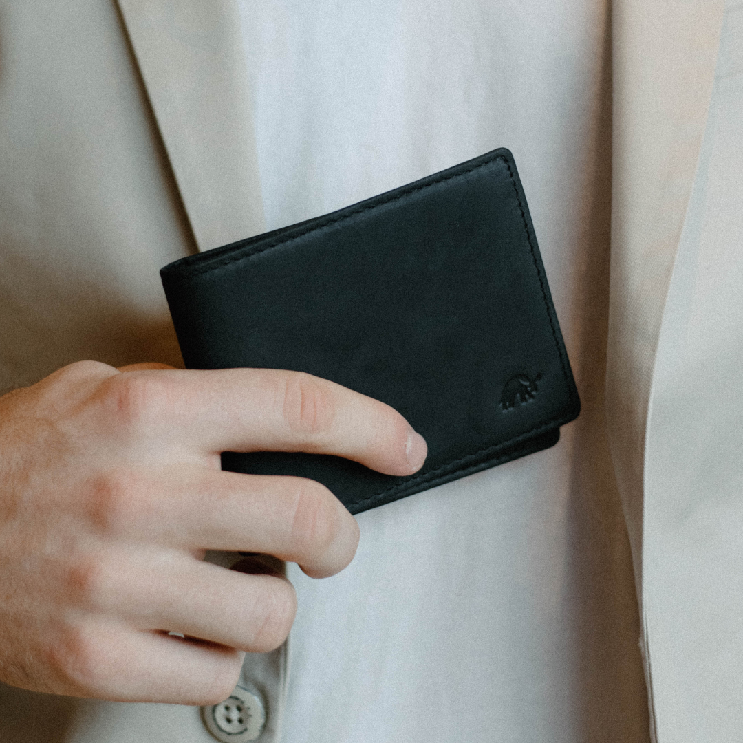 A person holding a black bifold wallet made of leather, featuring the Bullstrap logo.