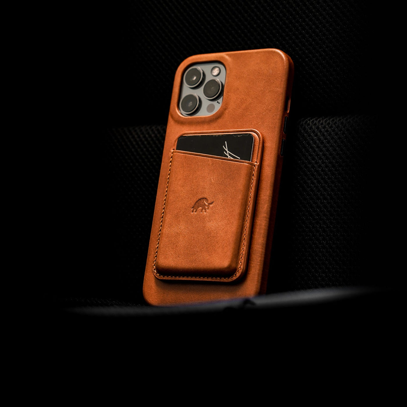 Brown leather phone case with card holder featuring an embossed logo