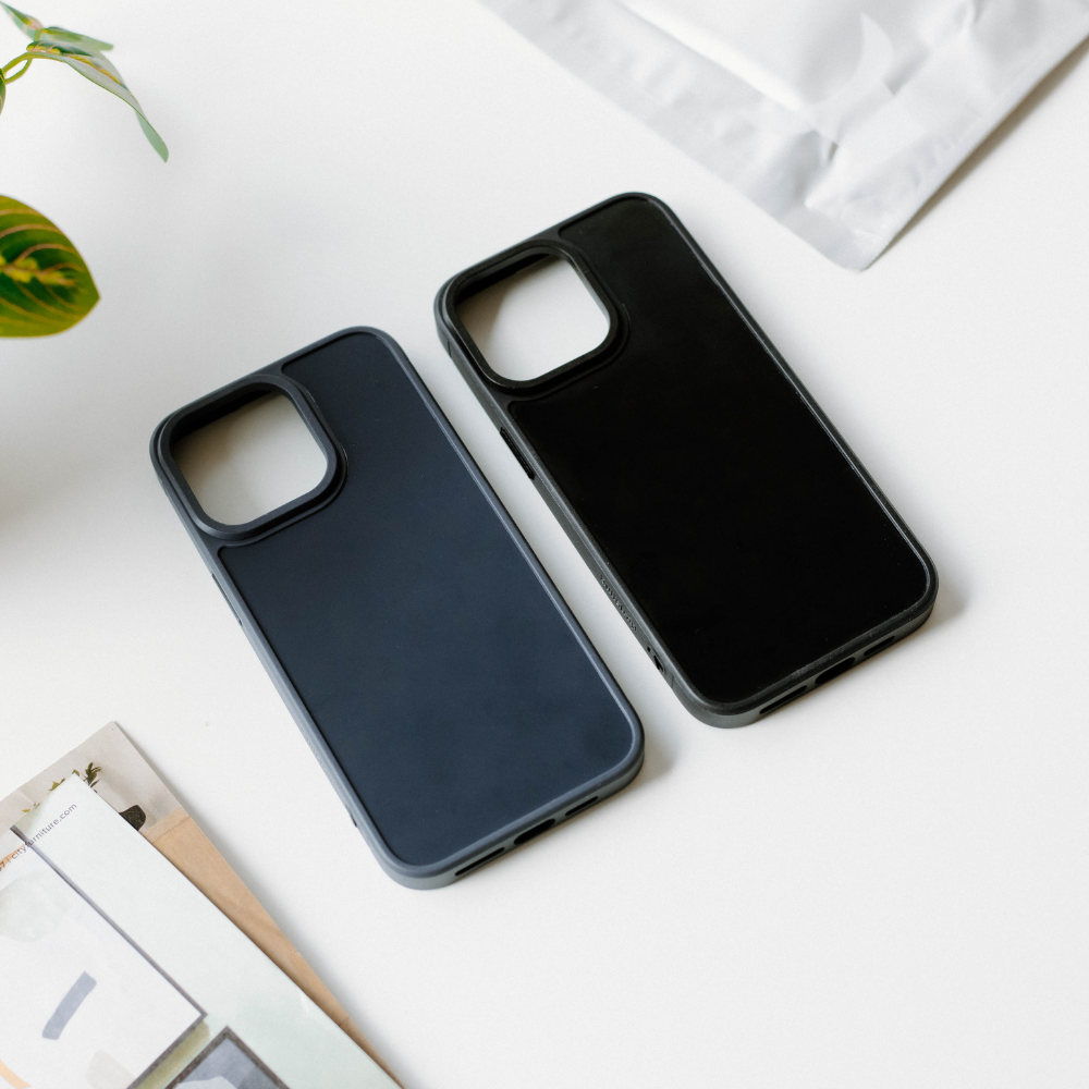 Two FRWD phone cases in black and dark gray on a white surface.