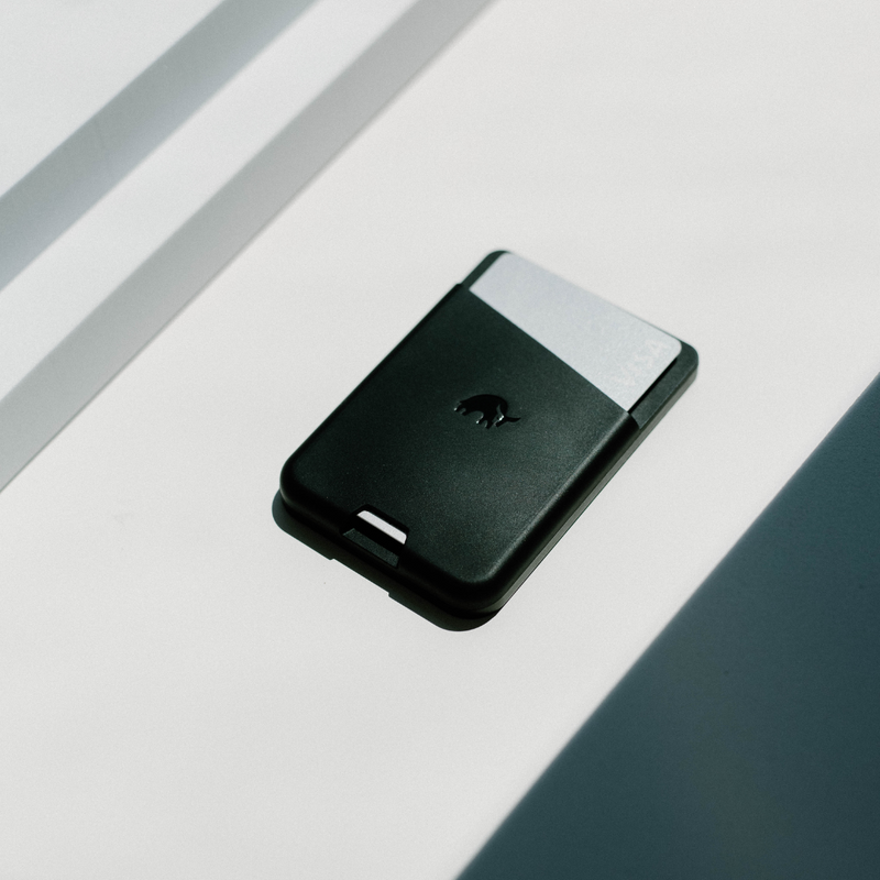 Black wallet with a silver card slot on a white surface