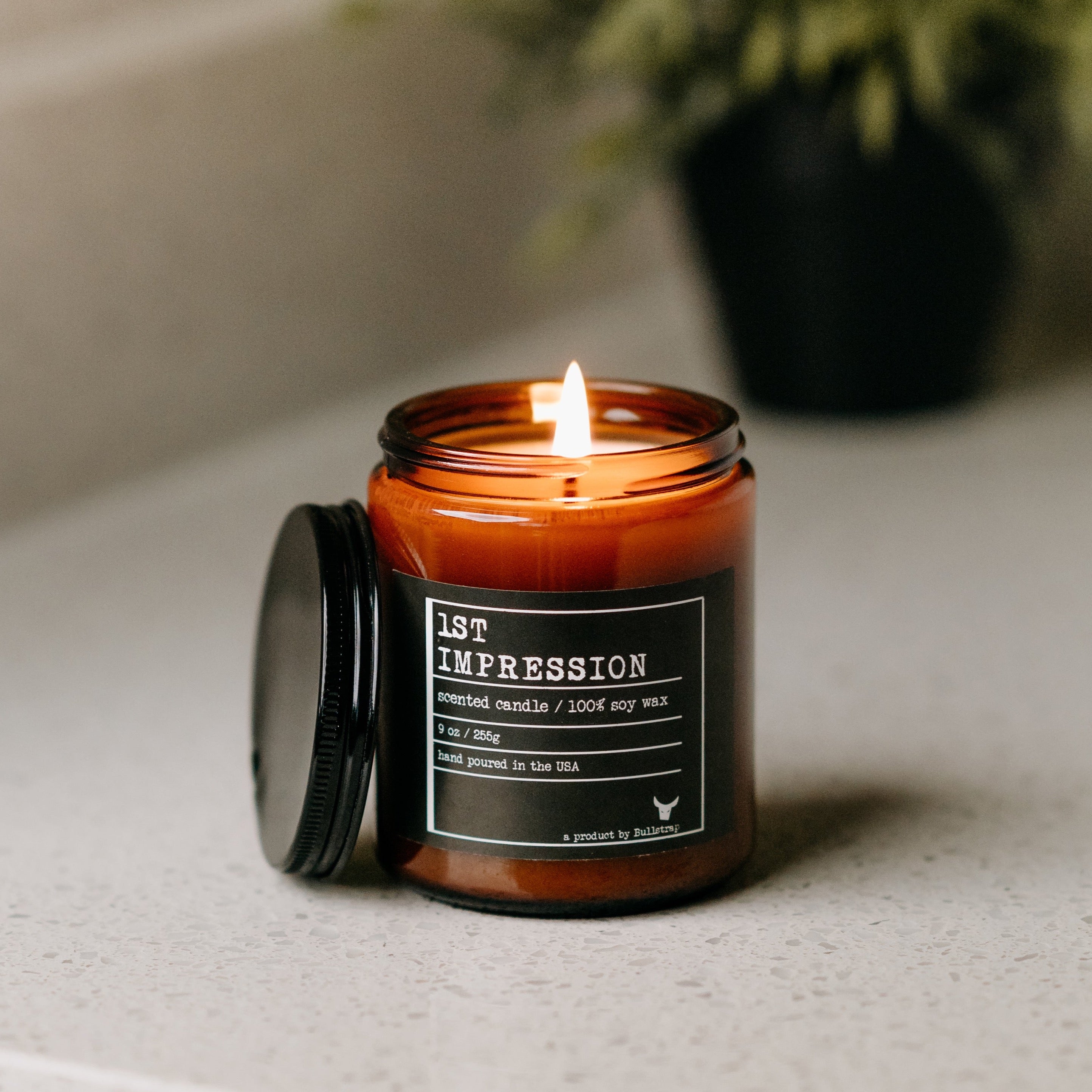 Jar candle labeled '1ST IMPRESSION, scented candle / 100% soy wax, 9 oz / 255g, hand poured in the USA'