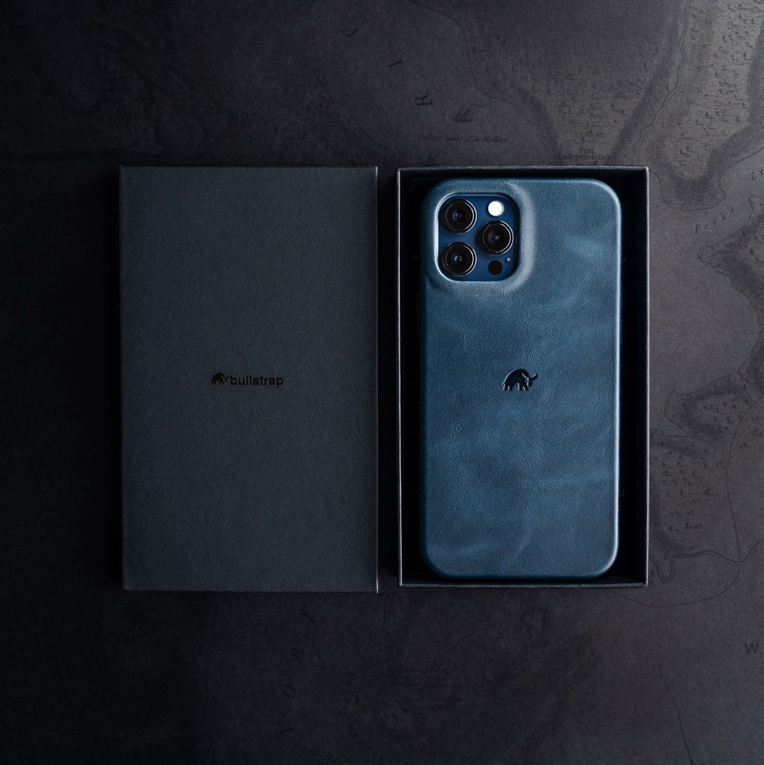 The Minimalist Case in Ocean color displayed in its packaging with a bullstrap logo.