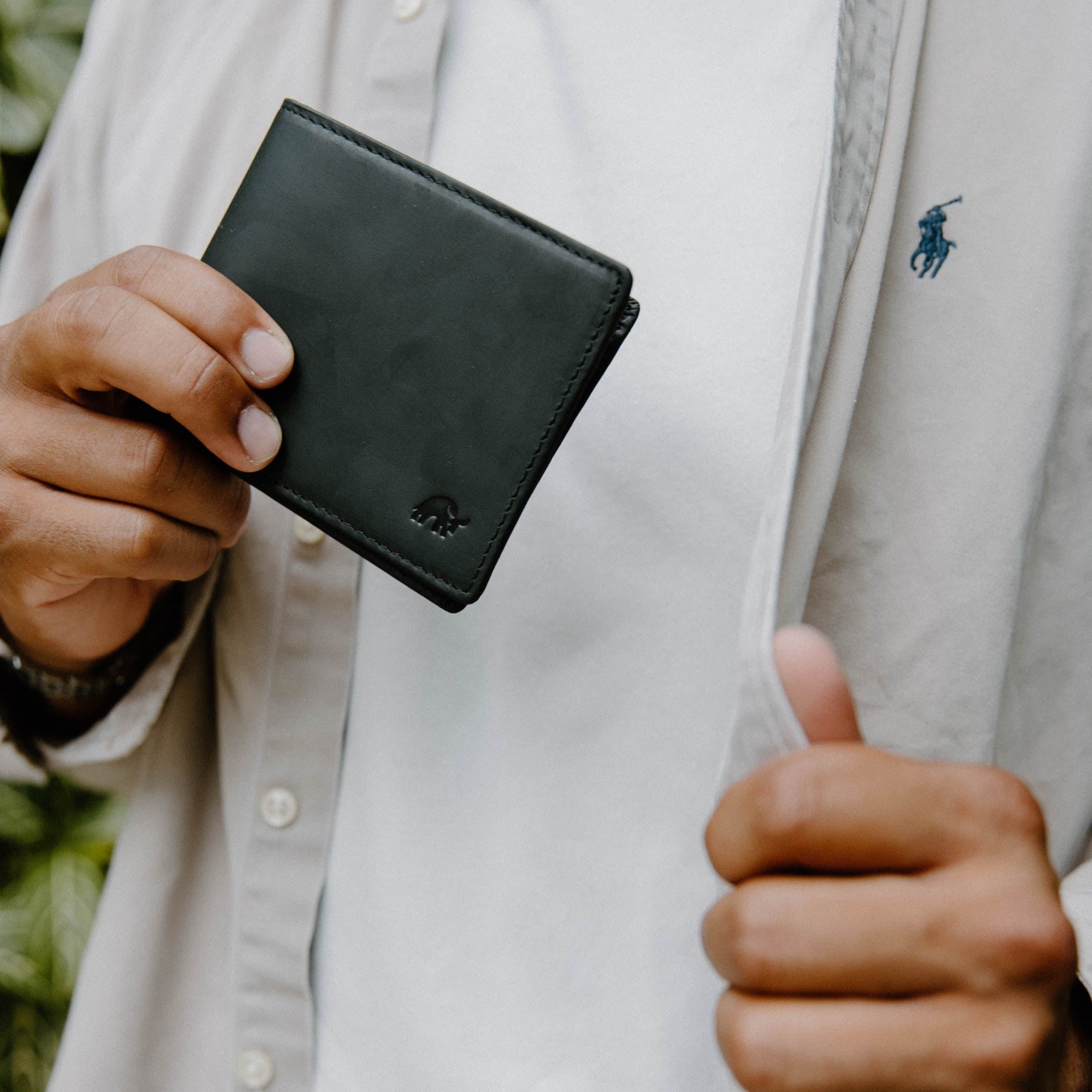 A person holding a Bifold Wallet - Black Edition, showcasing its design and texture.