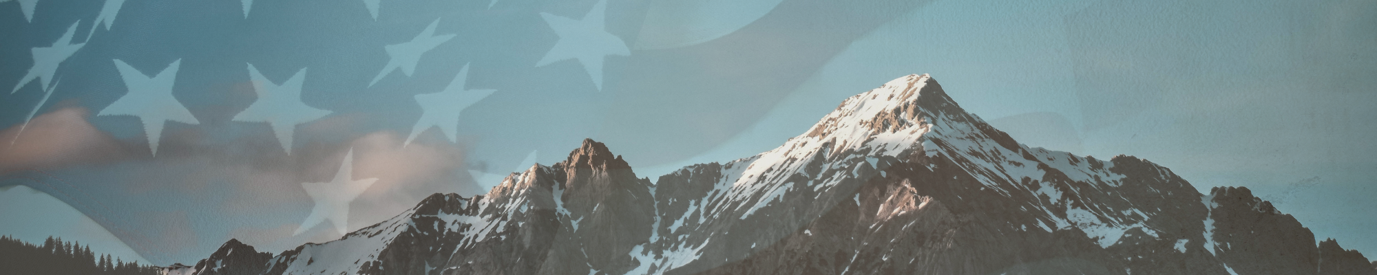 A mountain peak with snow and a faded American flag in the background