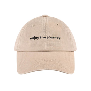 EYJ Badge Hat in tan with 'enjoy the journey' text on the front