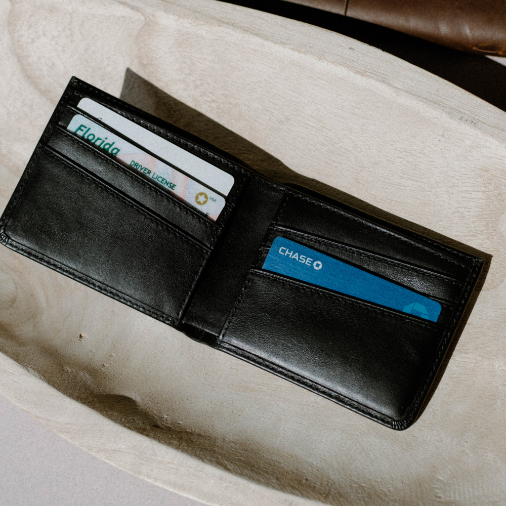 Black leather bifold wallet open; Florida DRIVER LICENSE (USA) in left slot and blue CHASE card in right slot.