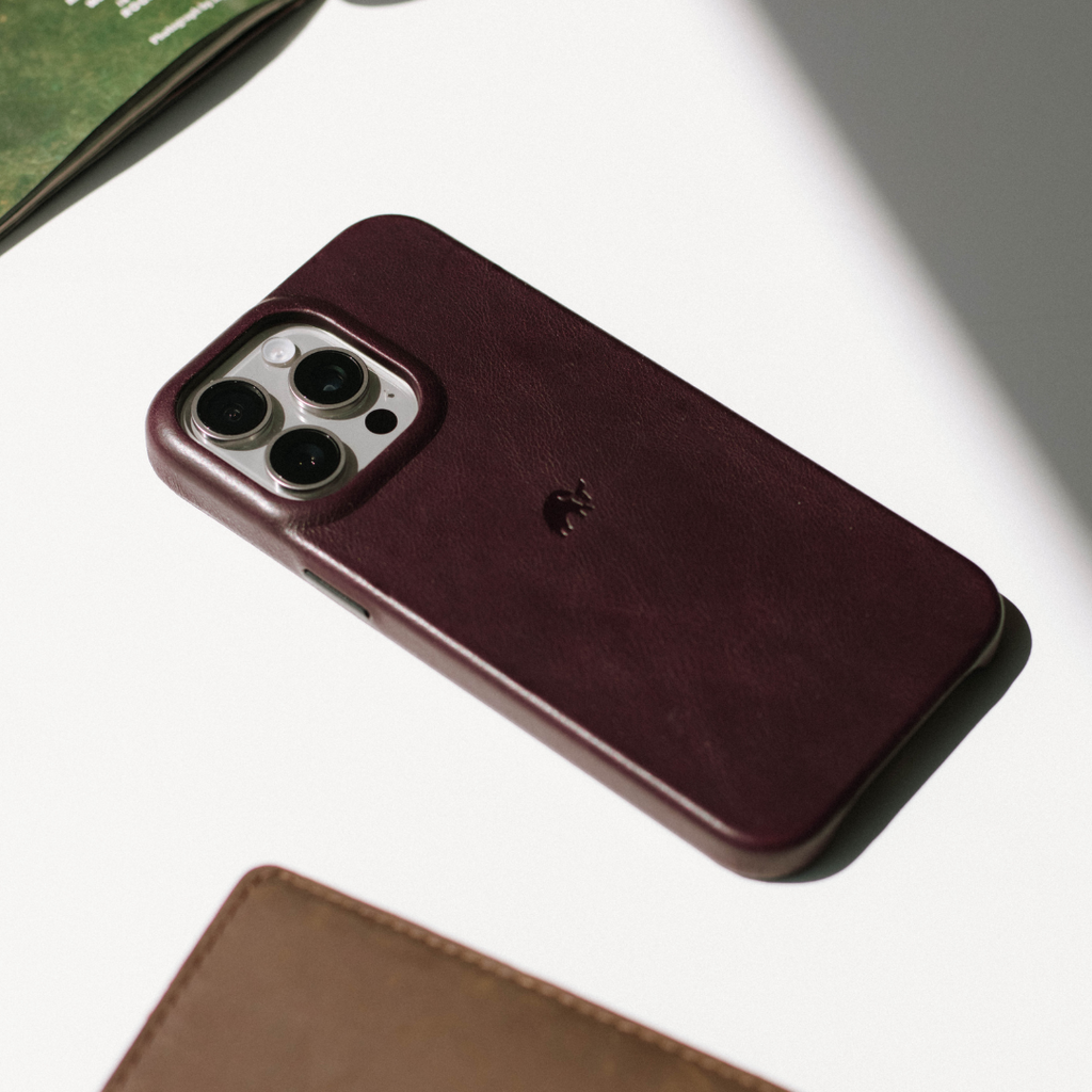 The Minimalist Case in DUNE color, showing the back of an iPhone with a leather case.