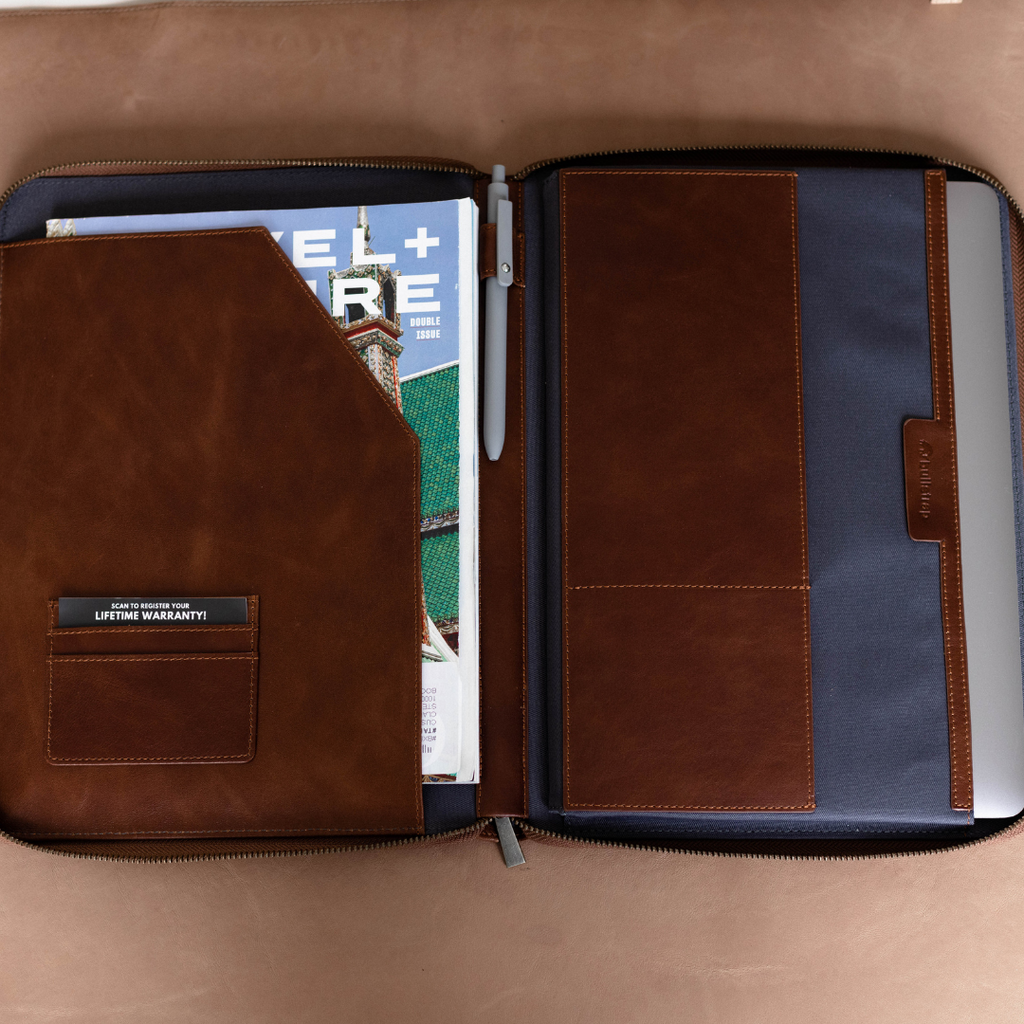 Open leather MacBook sleeve showing interior compartments and magazine.