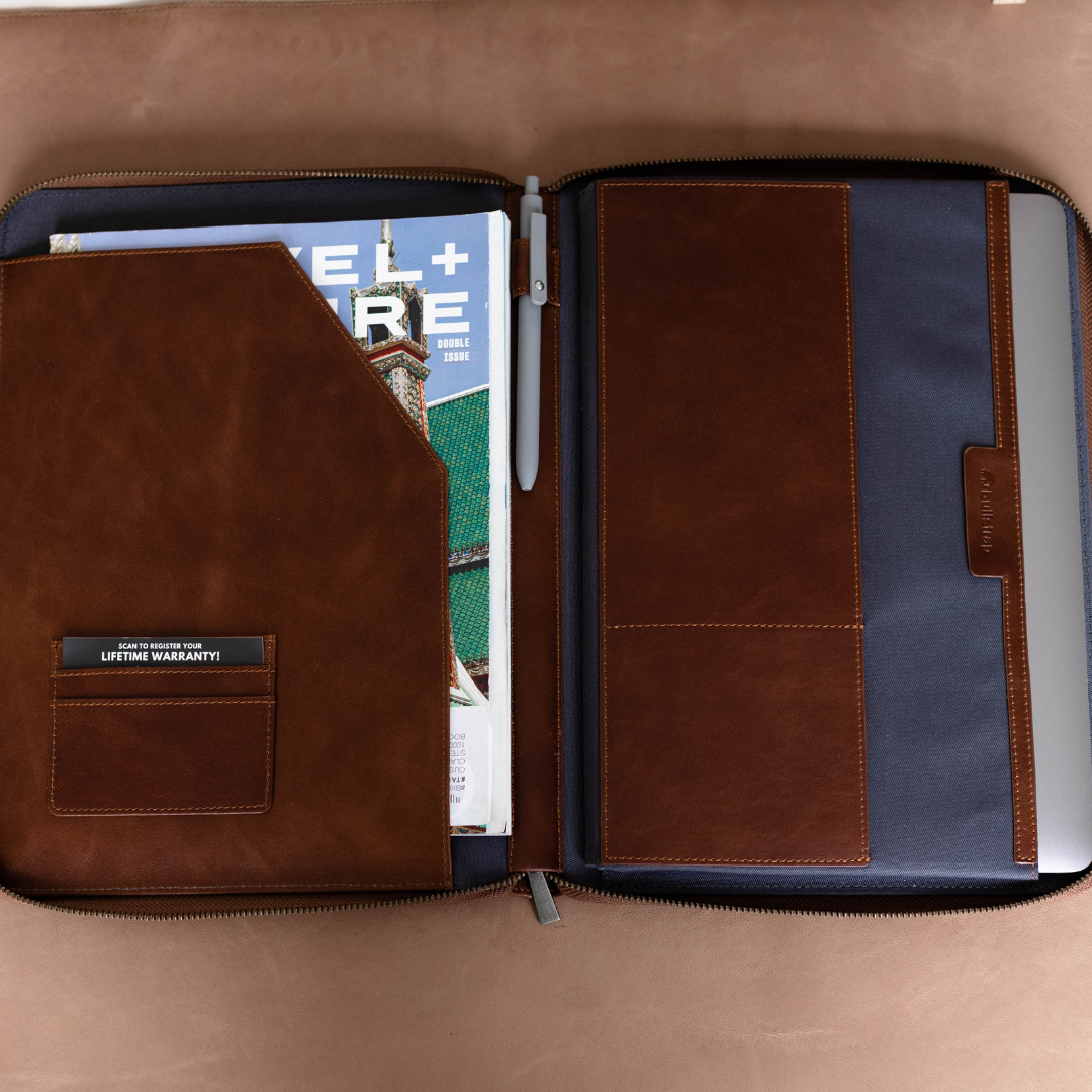 Open leather MacBook sleeve showing interior compartments and magazine.