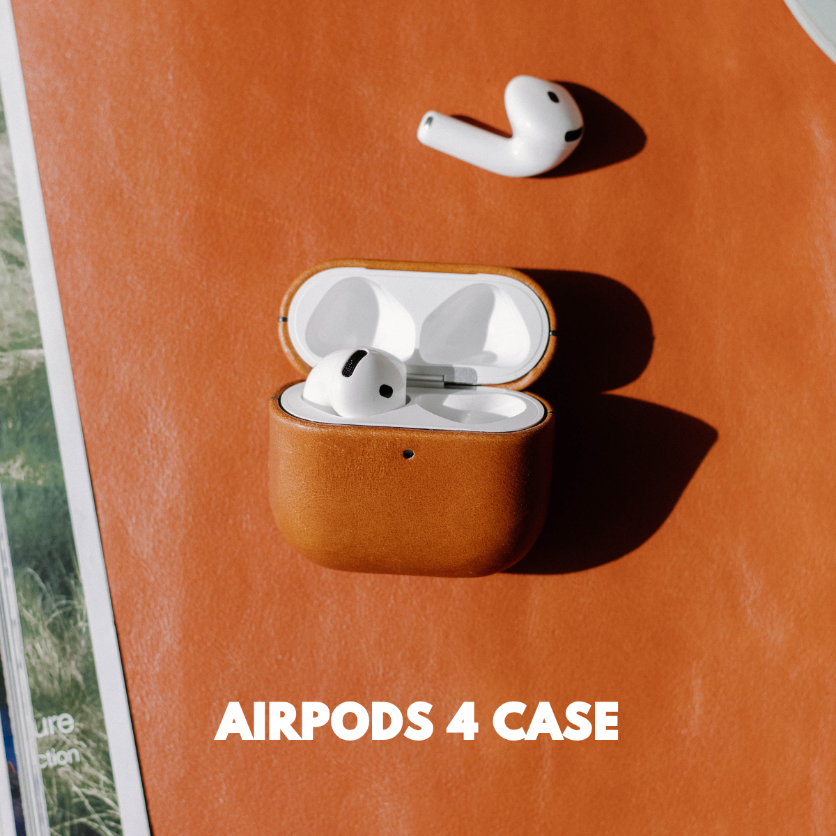 AirPods 4 case on a leather surface with AirPods nearby