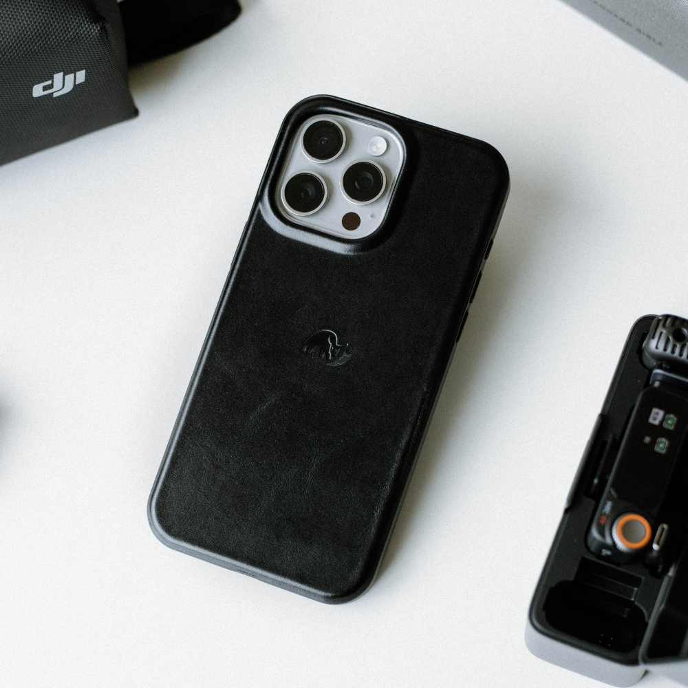 Black leather iPhone case with camera cutout on a white surface