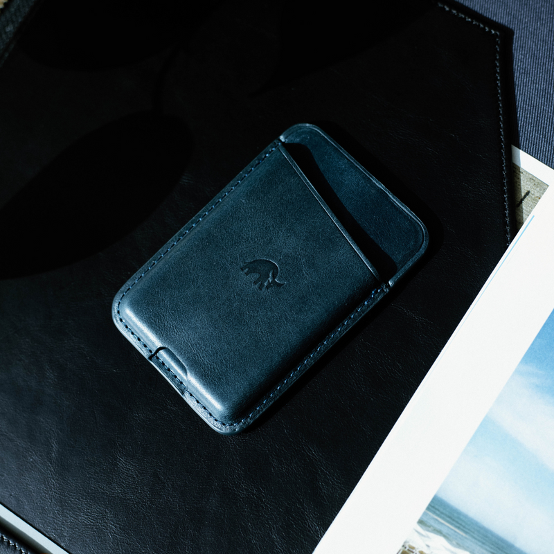 Leather wallet on a black surface, with a logo visible.