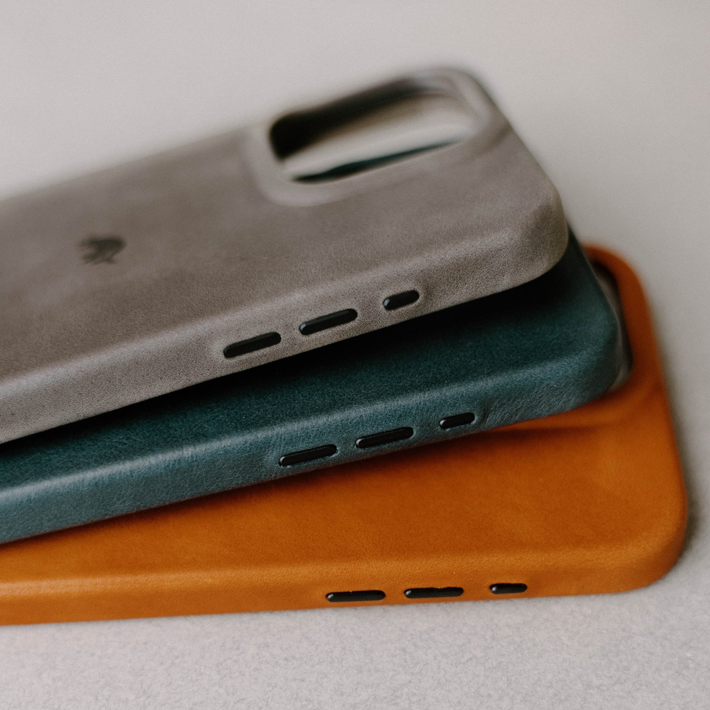Close-up side view of Contemporary Case in ocean showing leather texture and speaker cutouts, stacked over two other colors