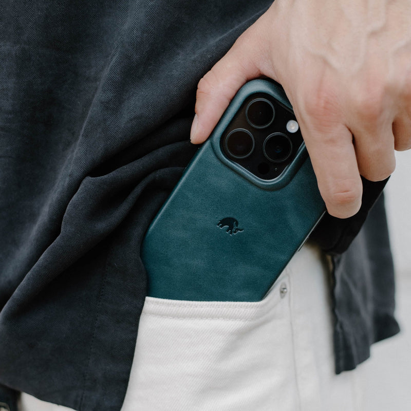 A hand holding a Bullstrap iPhone case in a pocket.