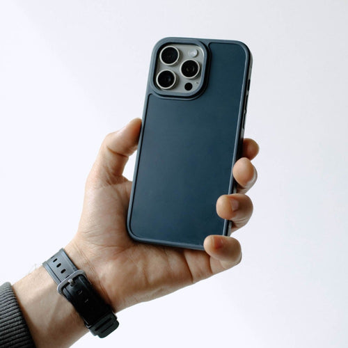 Navy blue slim phone case held in hand with raised camera cutout for triple-lens phone.