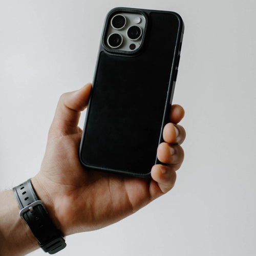 Hand holding a black matte smartphone case showing the camera cutout and raised edges
