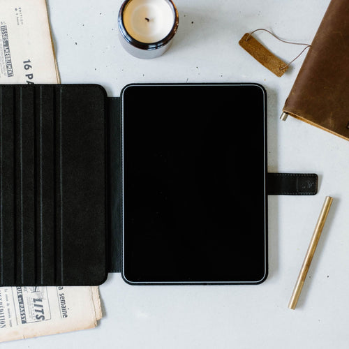 Open leather iPad case with a black interior and a tablet inside.