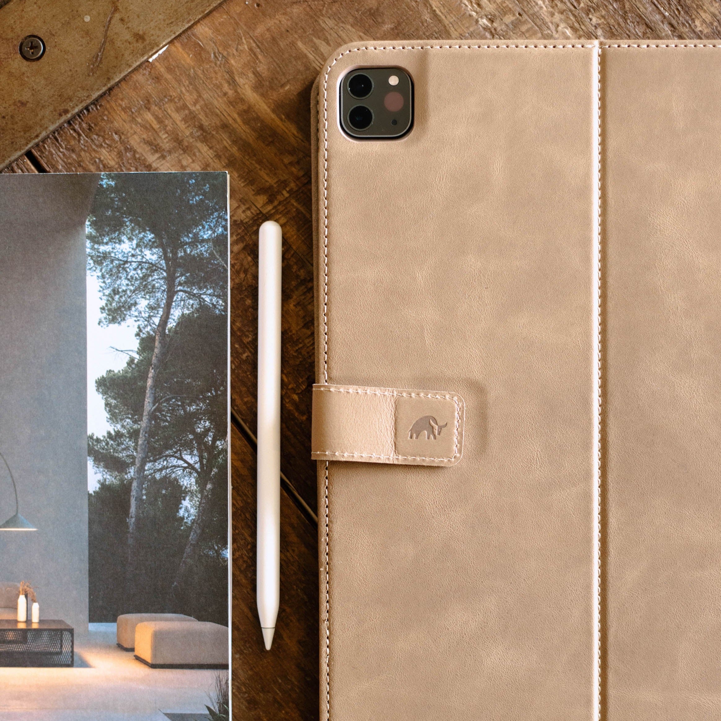 Leather iPad Case in Dune color, with a stylus beside it on a wooden table