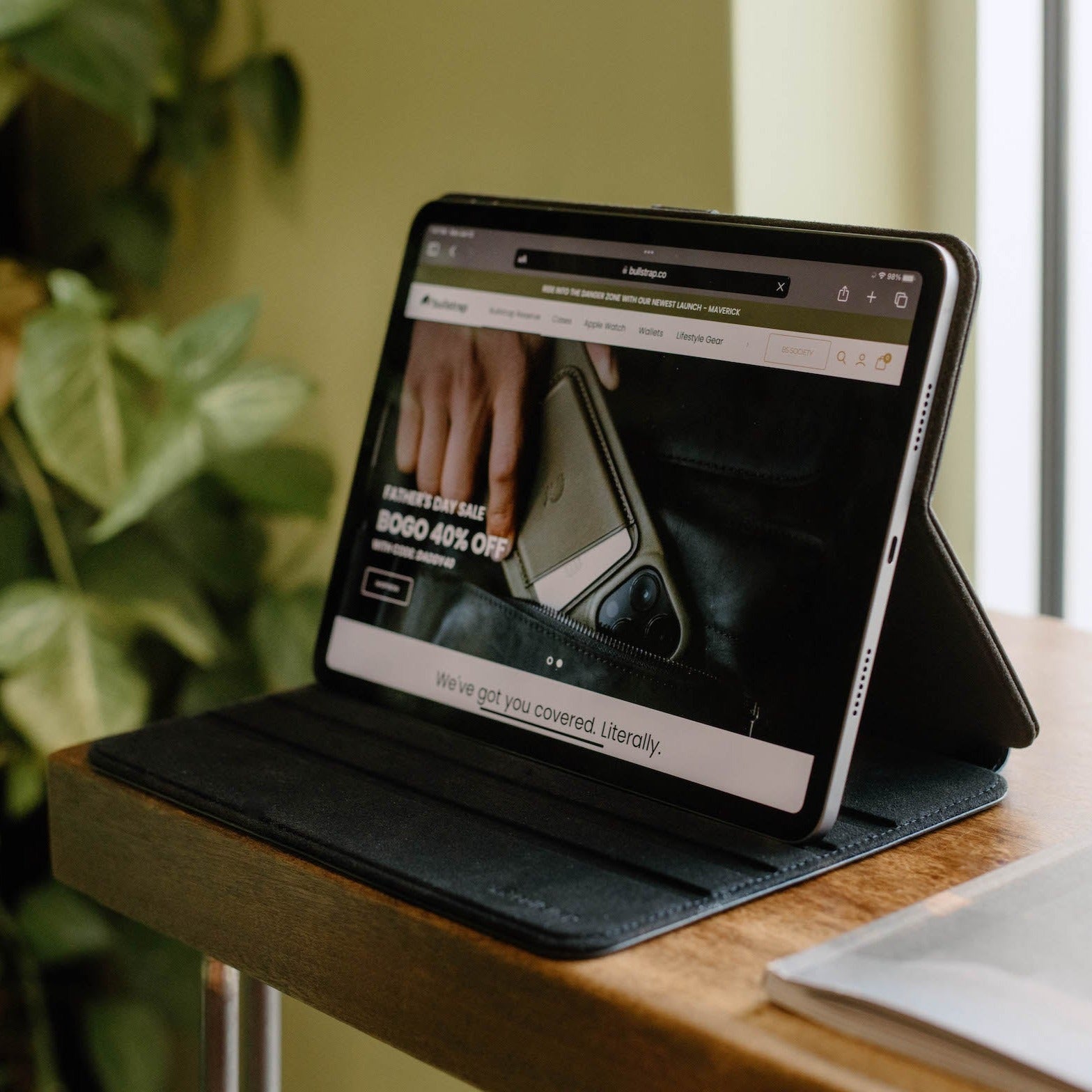 Leather iPad case propped on a table; screen banner reads BOGO 40% OFF and We've got you covered. Literally.