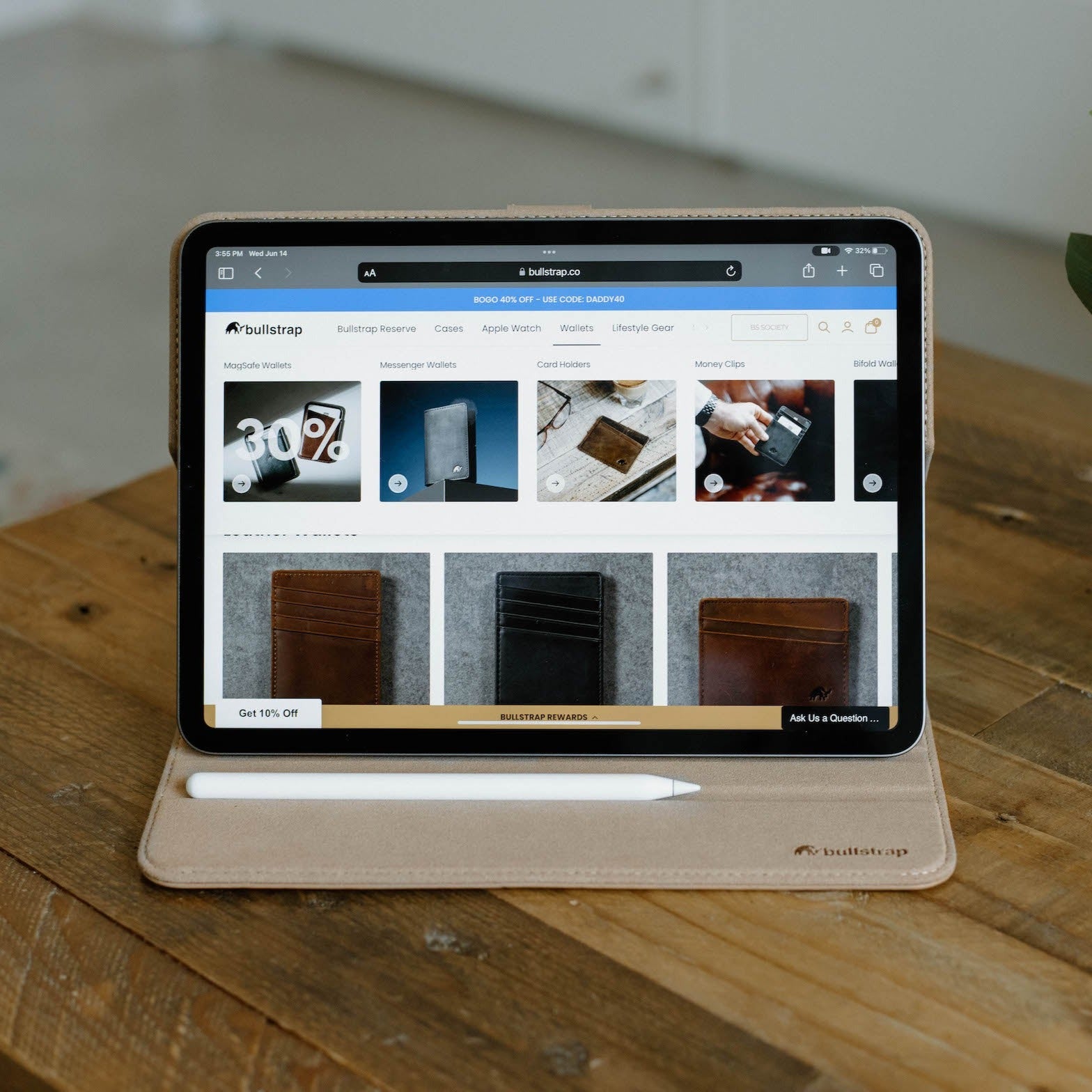 Leather iPad Case in Dune color displayed on a wooden table with an iPad showing various products.