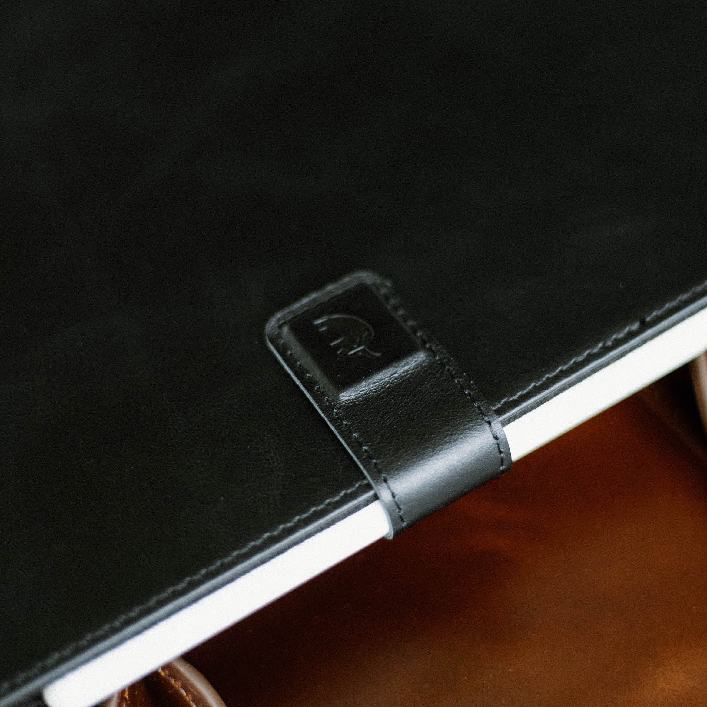 Close-up of the Leather iPad Case in Black Edition, showing the embossed logo and leather texture.