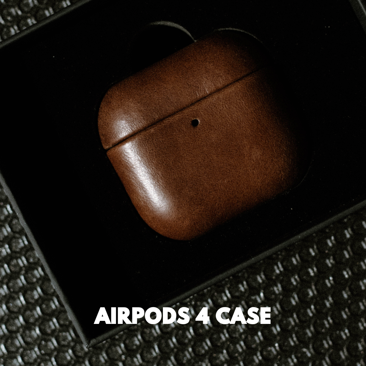 Brown leather AirPods 4 Case (Terra) in black tray, including the visible words AIRPODS 4 CASE.