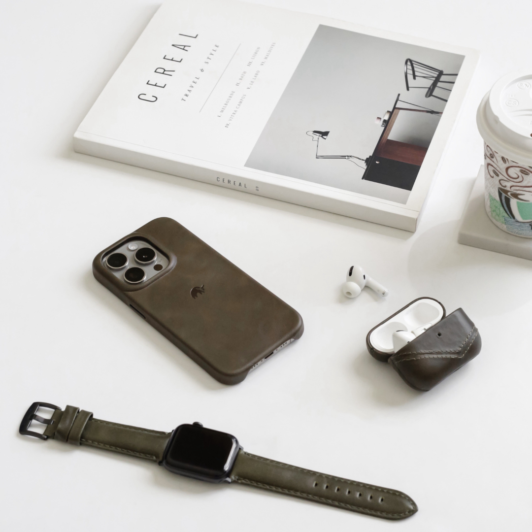 Flat lay of leather phone case, leather AirPods pouch, watch and coffee beside magazine titled CEREAL — TRAVEL & STYLE