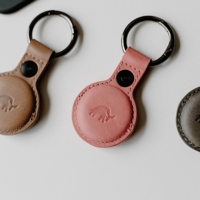 Top view of BullTag for AirTag in South Beach pink showcasing embossed bull logo and metal keyring on white background