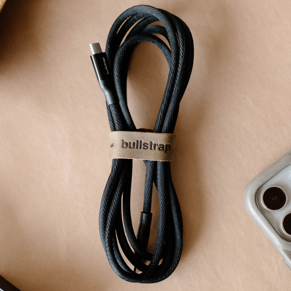 Black charging cable with leather tie labeled 'bullstrap'