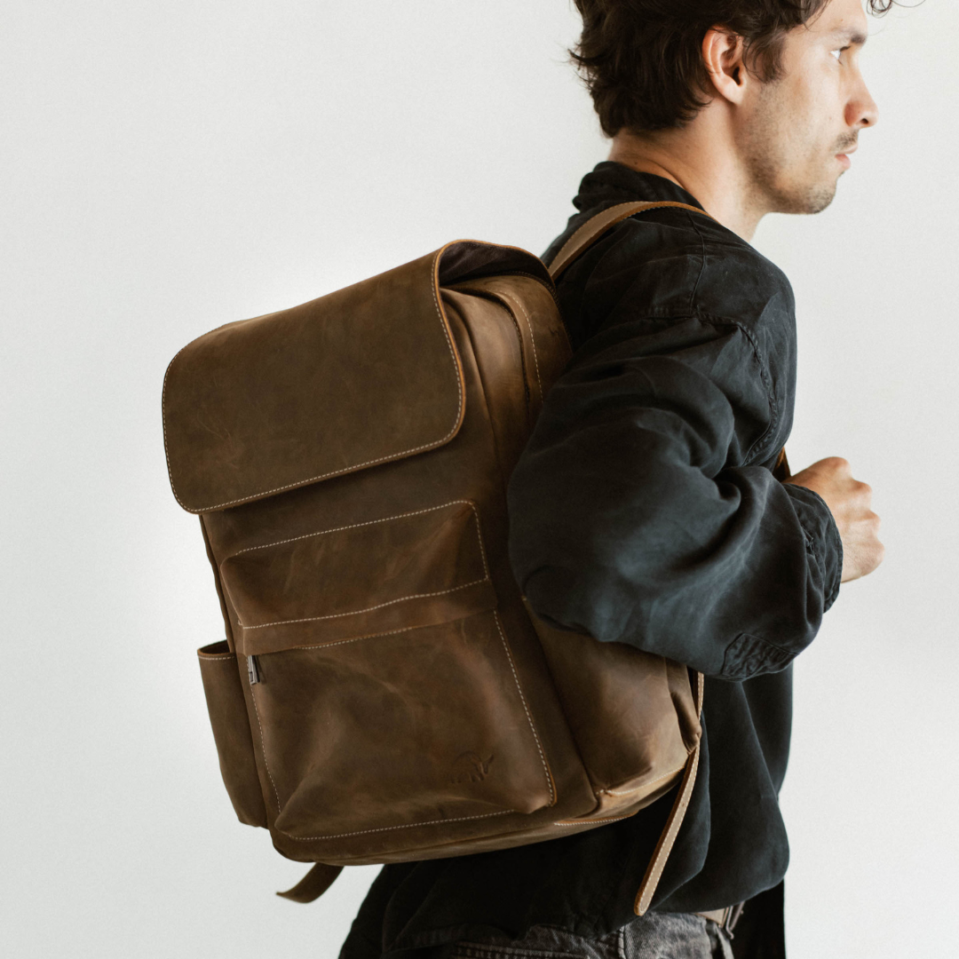 A man wearing a leather rugged backpack, showcasing its design and features.
