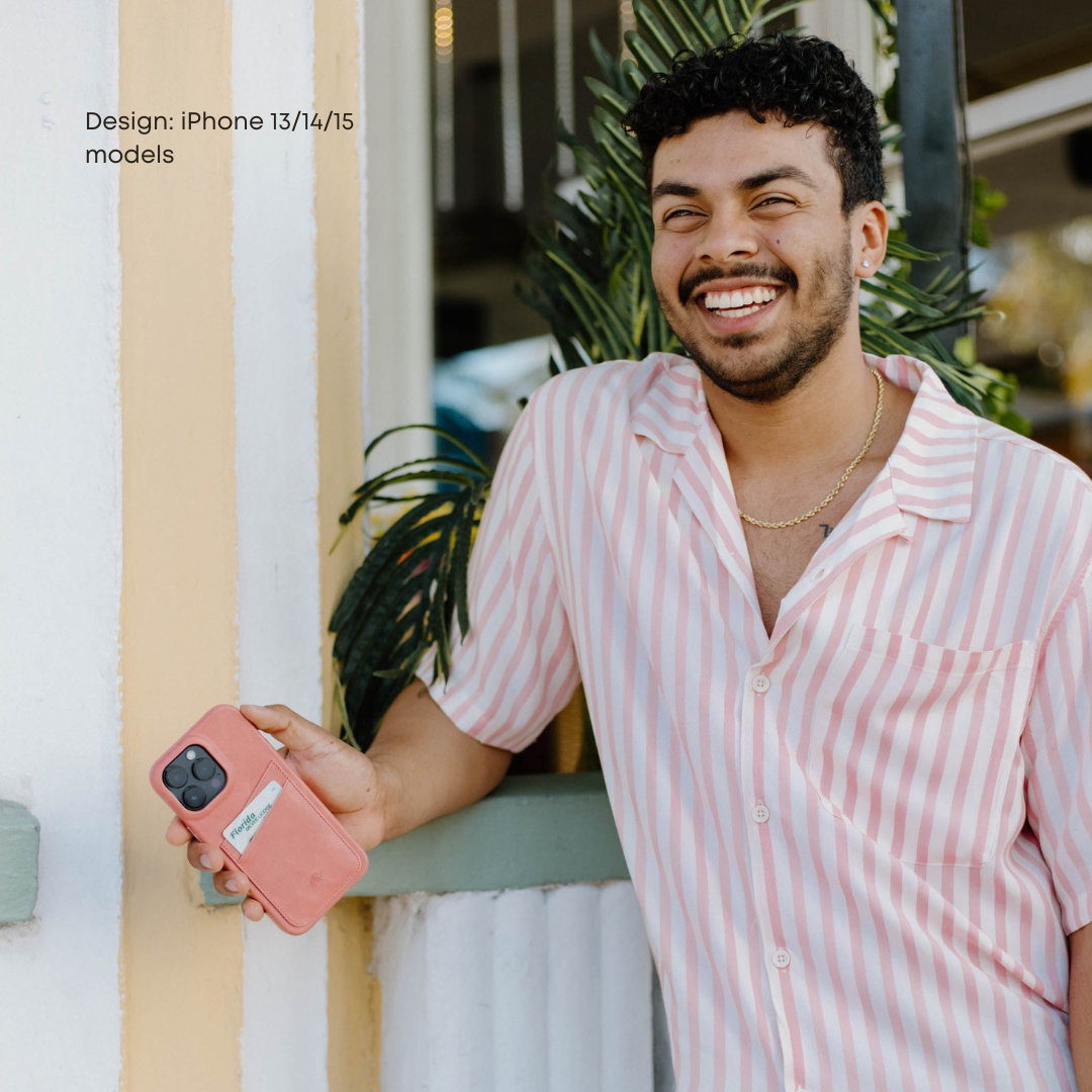 A person smiling while holding the Minimalist Portfolio Case in SOUTH BEACH color, standing near a plant.