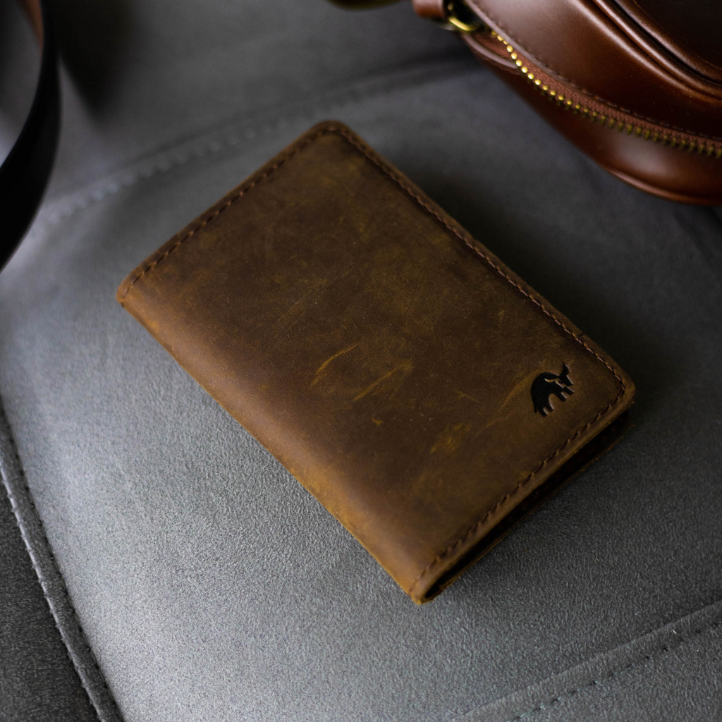 Brown leather Messenger Wallet on a gray surface with a Bullstrap logo
