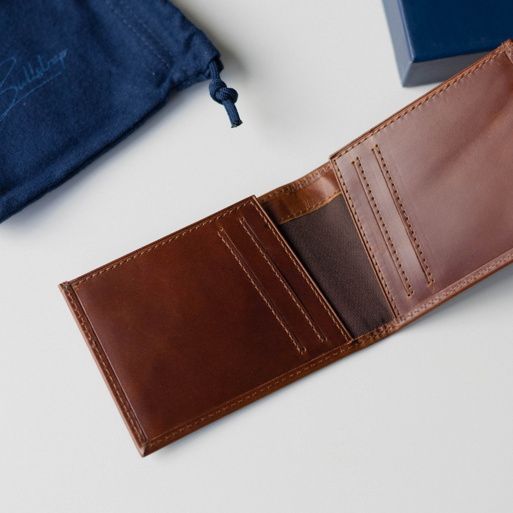 Open brown leather bifold wallet with card slots and cash pocket