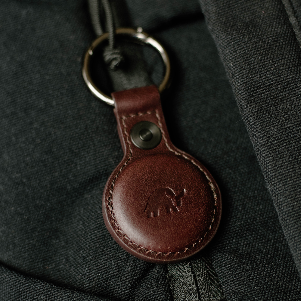 Brown leather BullTag keychain with a bull logo attached to a bag